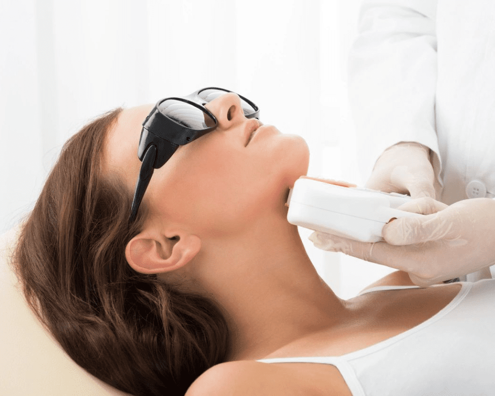 A woman getting her teeth checked by an esthetician.