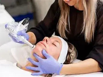 A woman getting her face waxed by an esthetician.