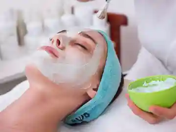 A woman is getting her face washed with a mask.