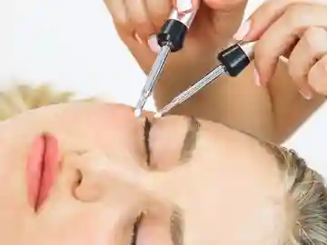 A woman is getting her face waxed