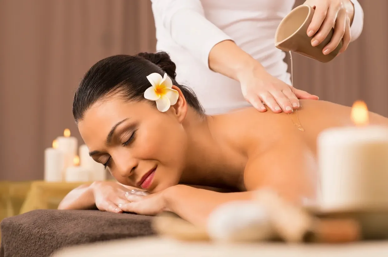 A woman getting her back touched by a masseuse.