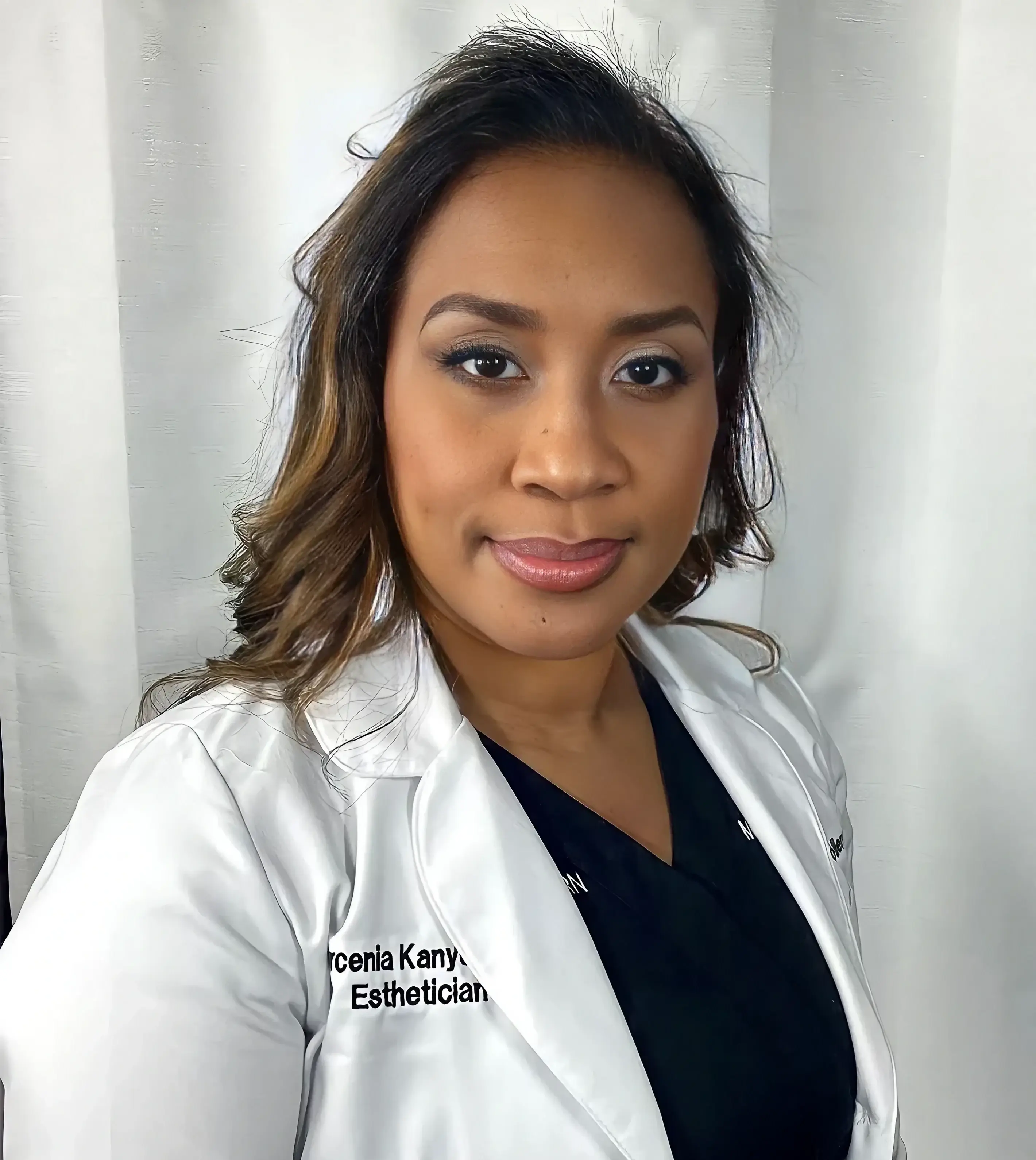 A woman in white lab coat and black shirt.