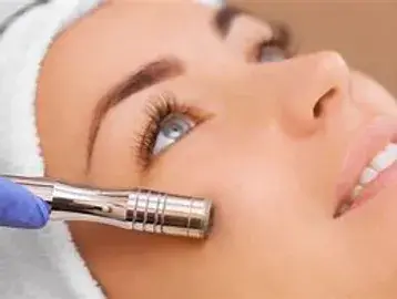 A woman getting her face shaped with an electric device.