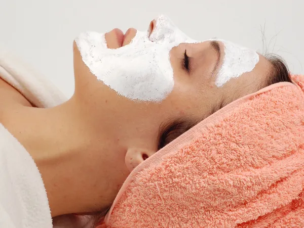 A woman with white face mask on laying down.