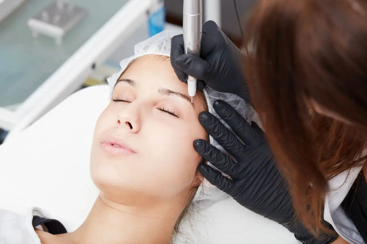 A woman getting her eyebrows shaved off