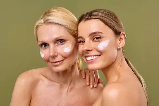 Two women with white creams on their faces.
