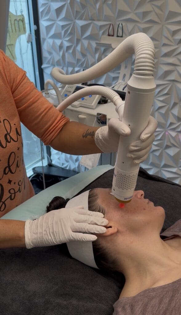 A person receives a laser facial treatment in a clinical setting.